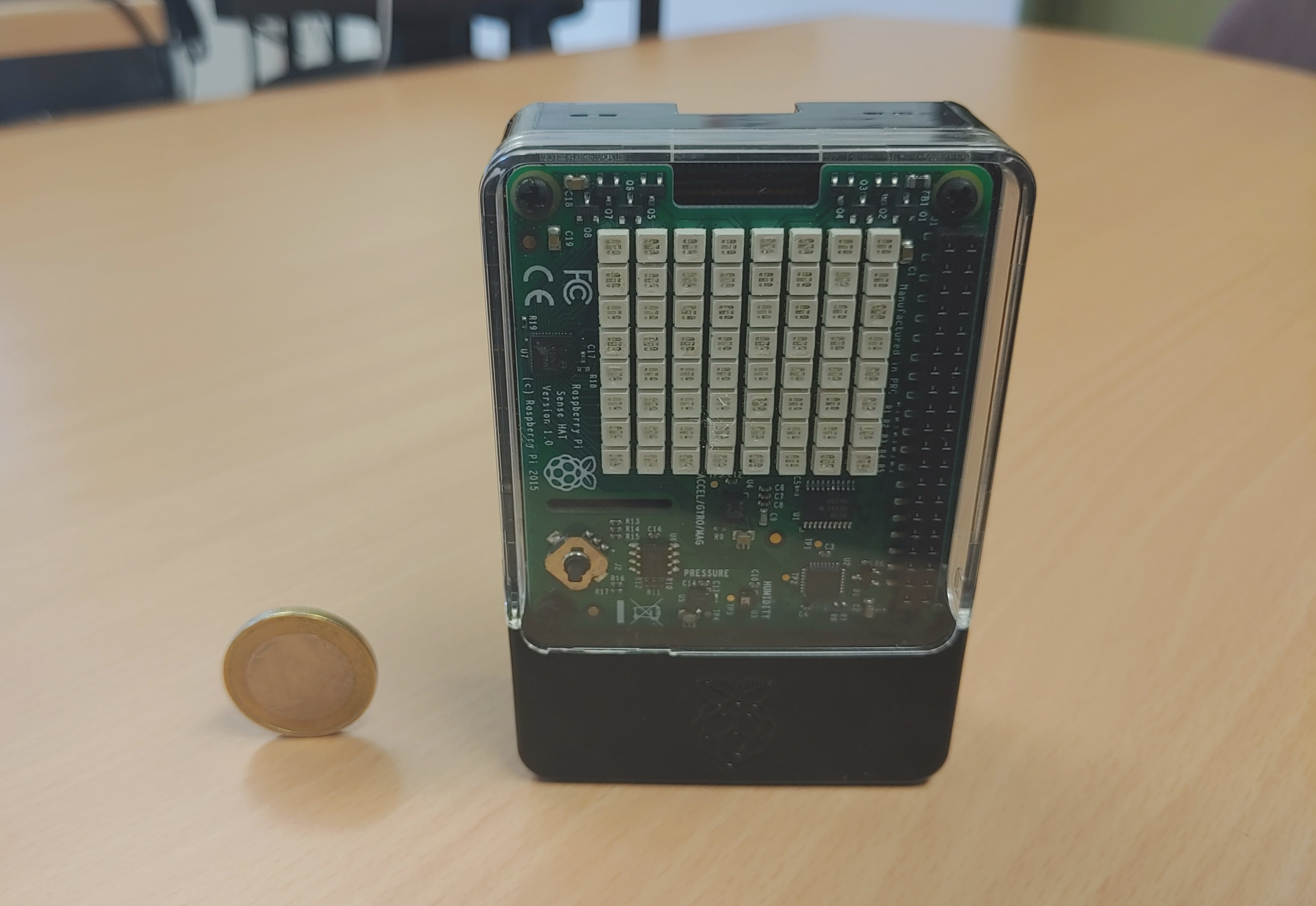 Raspberry-Pi-Minirechner mit Sense-HAT-Aufsatz neben 1€-Münze zum Größenvergleich